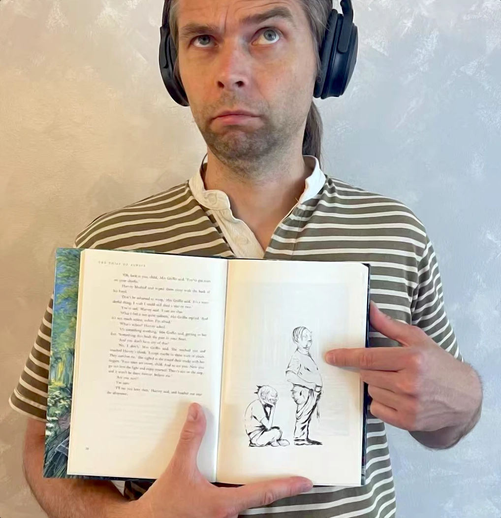 Photo of me holding the book, pointing at the drawing mentioned above.